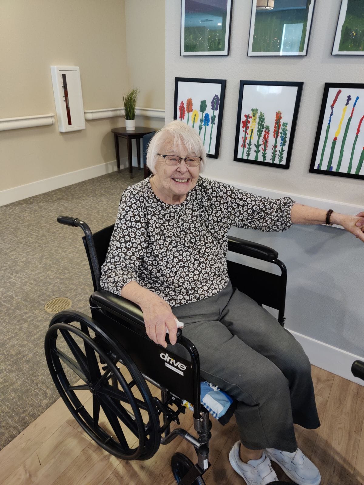 Resident posing in front of the art display at Cascade Creek