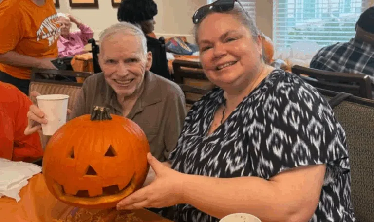 Residents of Porter Place Memory Care enjoy pumpkin decorating