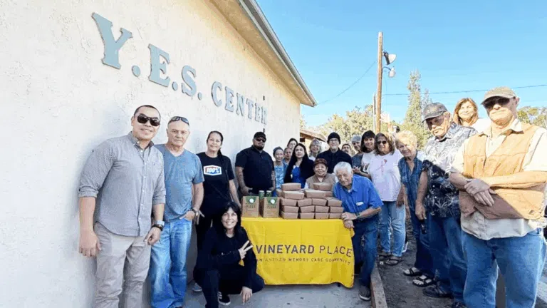 Residents and staff of Vineyard Place Memory Care serve breakfast to those in need at their local Y.E.S. facility