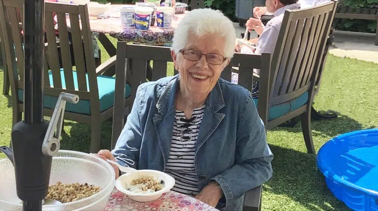 A resident of Emerald Place Memory Care in Glenview Illinois enjoys a bowl of chicken salad