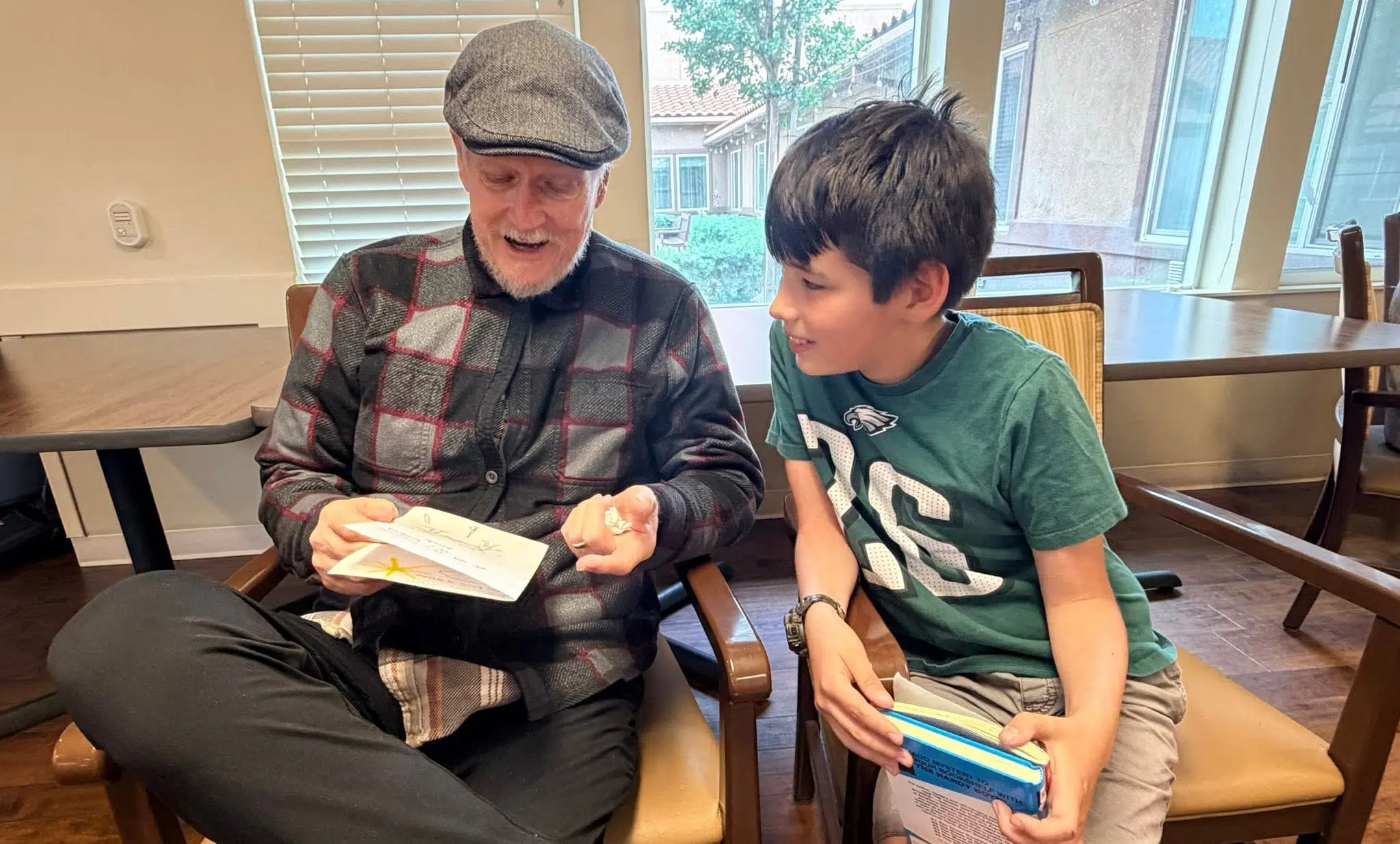 A resident of Vineyard Place Memory Care in Murrieta CA reads with a local school child